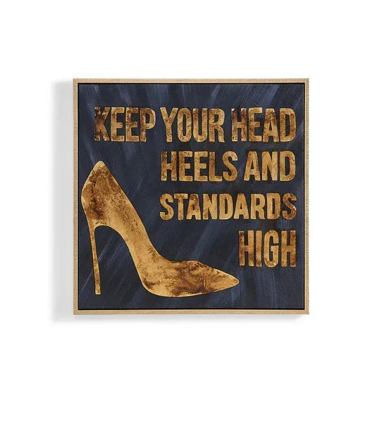 Gold high heel wall art with text 'Keep your head heels and standards high' on dark background