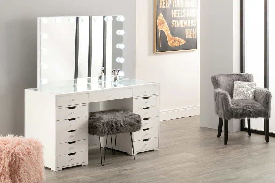 White dressing table with Hollywood mirror and grey faux fur stool in modern bedroom setting