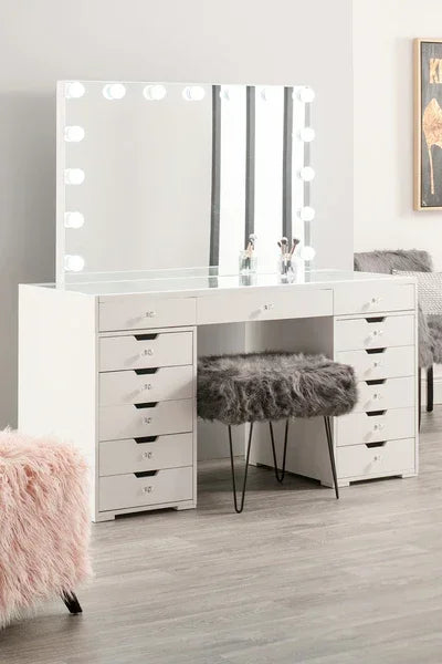 White makeup vanity table with mirror lights and faux fur stool in modern bedroom