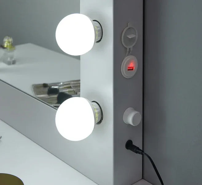 White vanity mirror with LED lights, USB port and makeup accessories on tabletop