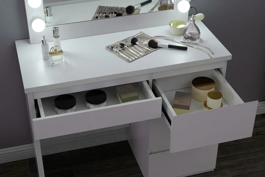 White dressing table with open drawers, makeup brushes, and round containers on surface