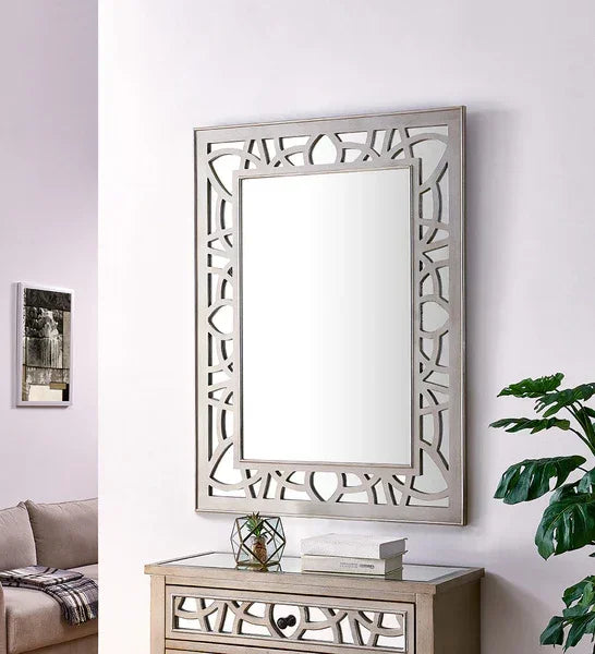 Rectangular wall mirror with geometric frame above wooden console in living room