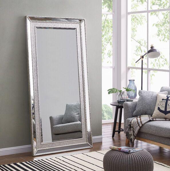 Large silver frame wall mirror in living room beside grey sofa and window