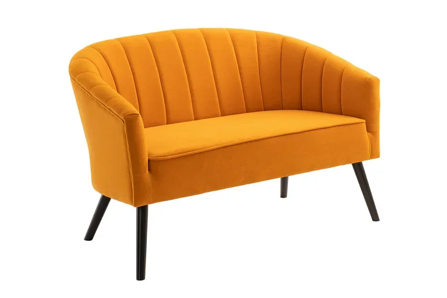 Mustard yellow velvet sofa with curved backrest and black angled legs