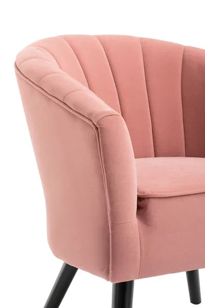 Blush pink velvet accent chair with curved back and black legs, angled side view