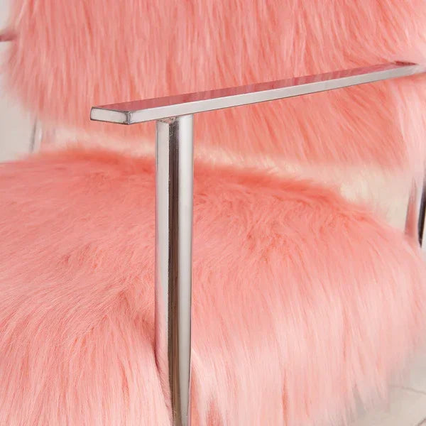 Pink faux fur accent chair with chrome metal armrest and seat closeup