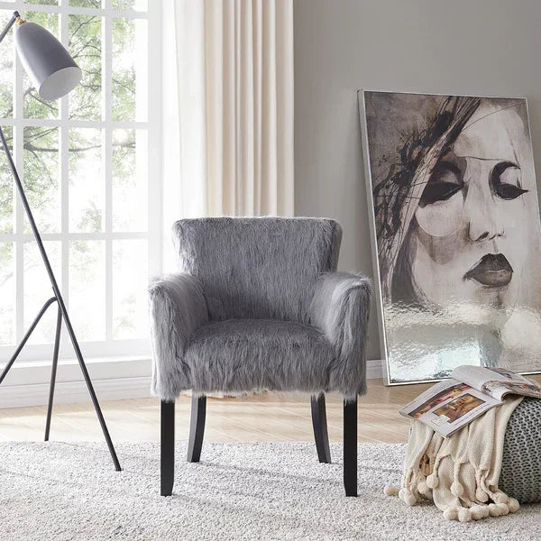 Grey faux fur accent chair with black legs in modern living room beside portrait artwork