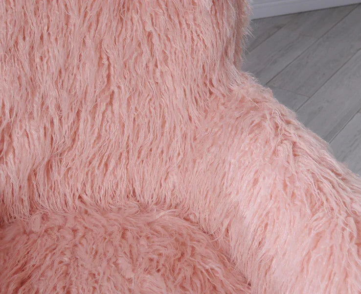 Pink faux fur accent chair with plush texture on wooden floor