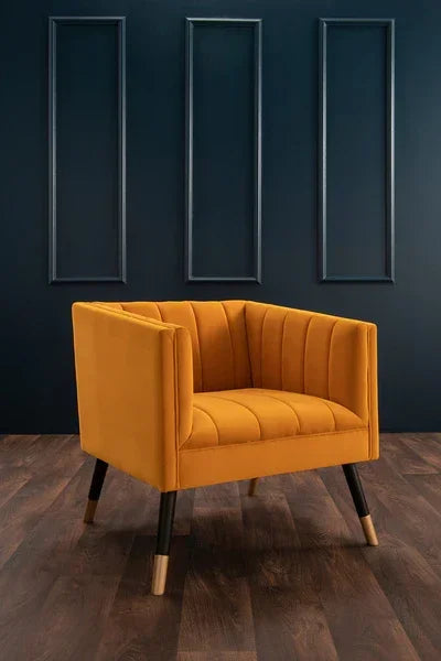 Mustard velvet accent chair with tapered wooden legs on hardwood floor