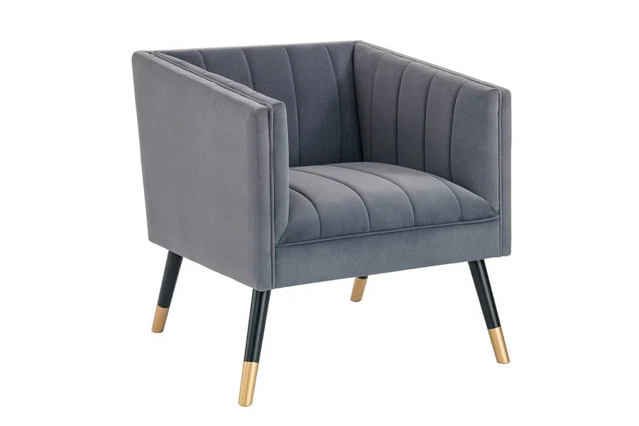 Grey velvet armchair with vertical channel stitching and black tapered legs with gold tips