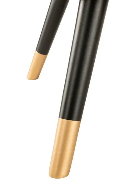 Black metal furniture legs with gold tips, close-up view