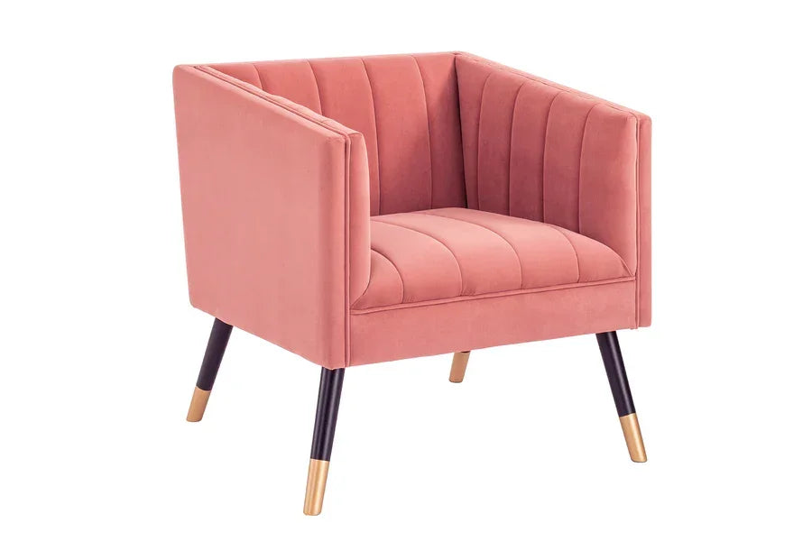 Pink velvet armchair with vertical channel tufting and gold-tipped black metal legs