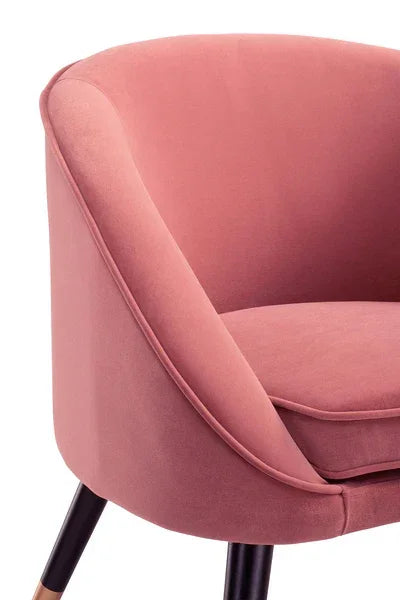 Pink velvet accent chair with curved back and black tapered legs