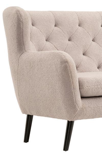 Beige boucle sofa with tufted backrest and black metal legs, close-up of armrest