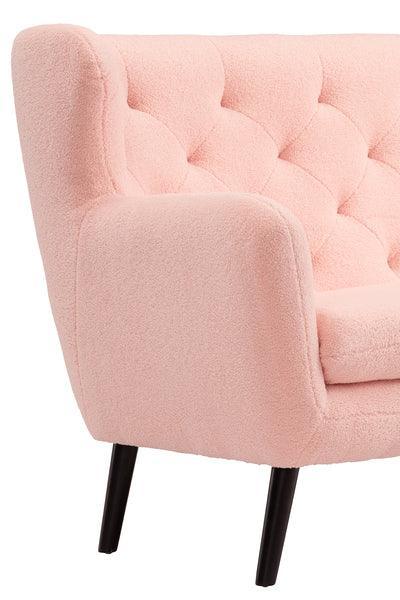 Light pink accent chair with tufted upholstery and black wooden legs, side angle view