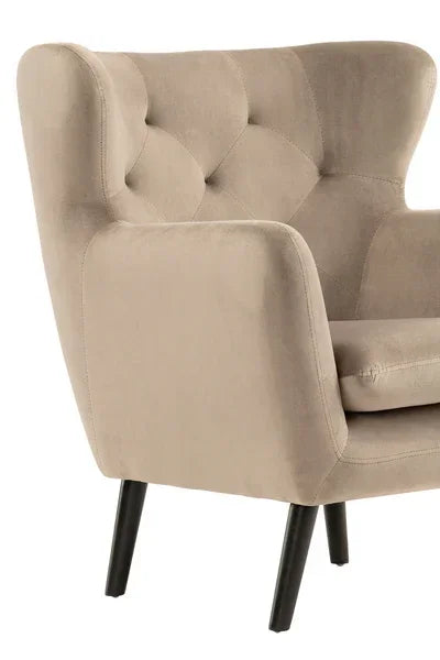 Beige armchair with tufted backrest and black angled legs, close side view