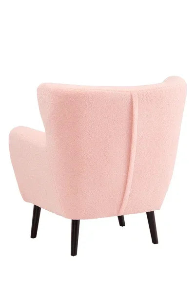 Blush pink accent chair with fabric upholstery and black wooden legs, rear view angle