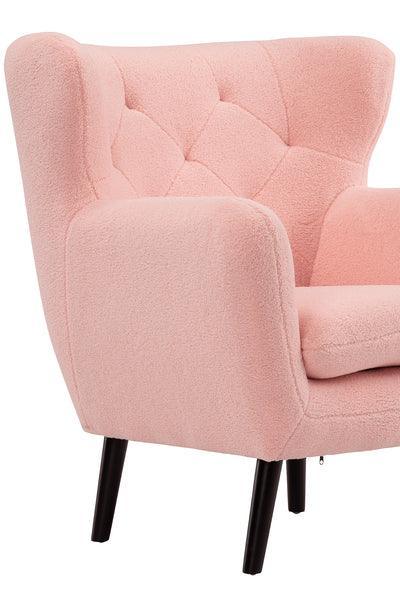 Pink armchair with tufted backrest and wooden legs, close-up of seat and arm detail