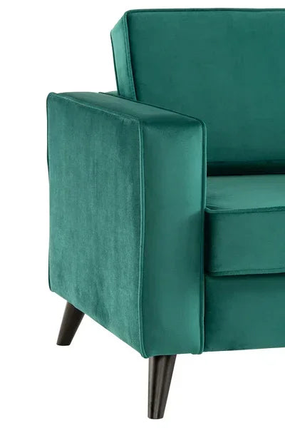 Green velvet sofa arm detail with black wooden legs, modern furniture close-up