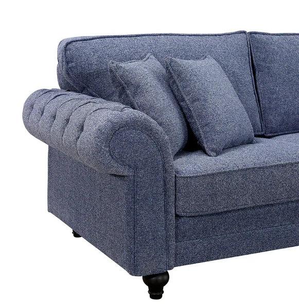 Blue fabric sofa with tufted armrest and matching scatter cushions, left side view