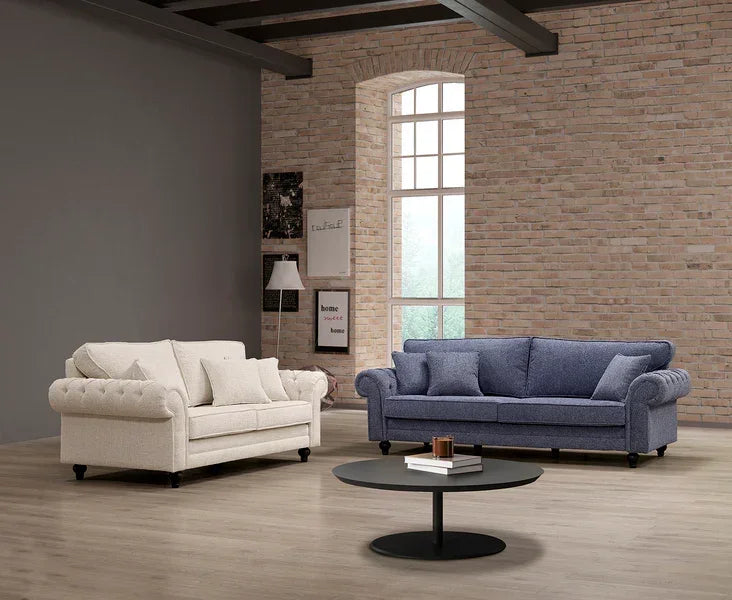 Cream and blue fabric sofas with rolled arms in modern living room, round coffee table in front