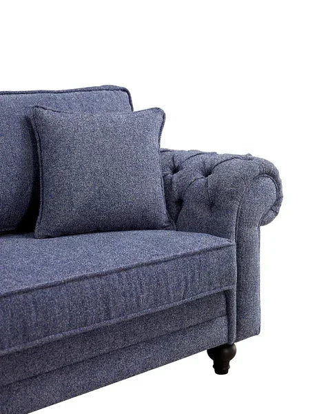 Blue fabric sofa with cushion and tufted armrest, close side view