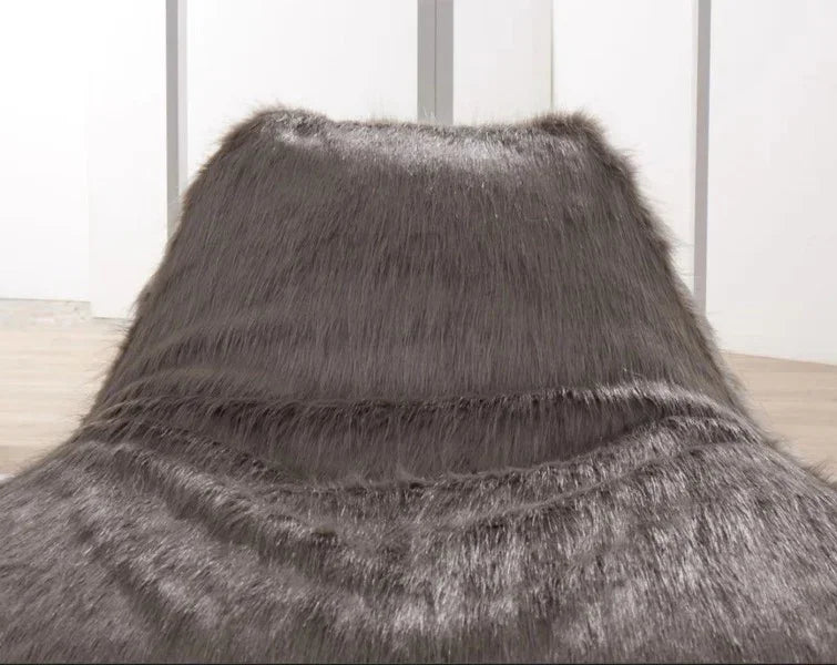 Dark grey faux fur bedspread draped on bed in modern bedroom
