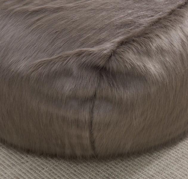 Round faux fur bean bag in grey on neutral textured carpet