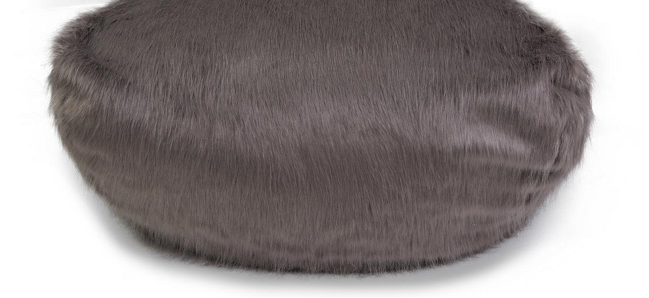 Grey faux fur pouffe bean bag with round shape on white background