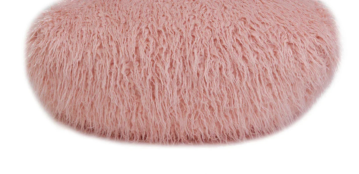 Round pink faux fur pouffe with textured surface on white background