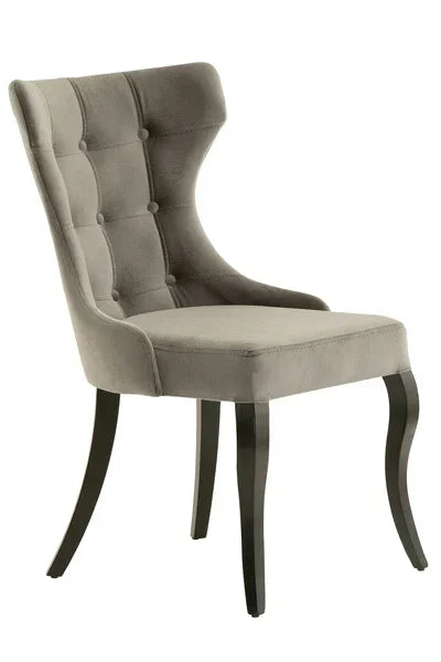 Grey velvet dining chair with tufted backrest and dark wooden legs, side angle view
