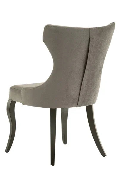 Grey velvet dining chair with curved backrest and dark wooden legs, rear angle view