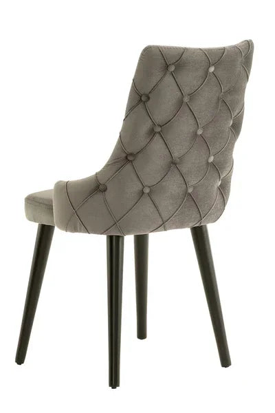 Grey velvet dining chair with button-tufted backrest and black tapered legs, rear view