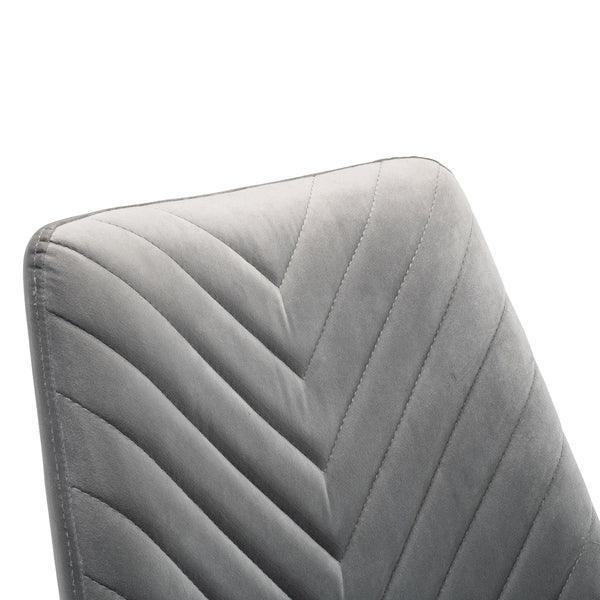 Grey velvet dining chair with chevron stitched backrest, close-up view