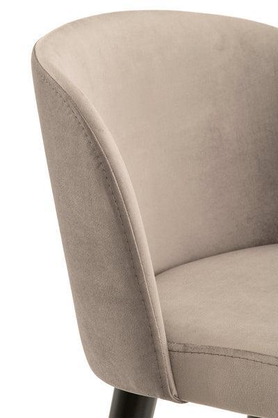 Close-up of beige fabric dining chair with curved backrest and black legs
