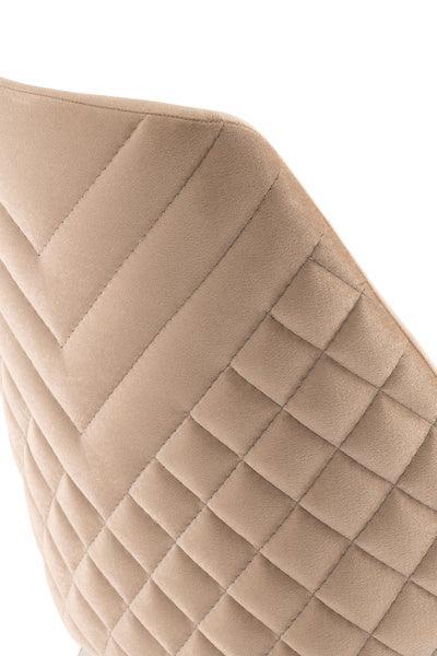 Close-up of quilted beige velvet dining chair backrest with diamond stitching detail