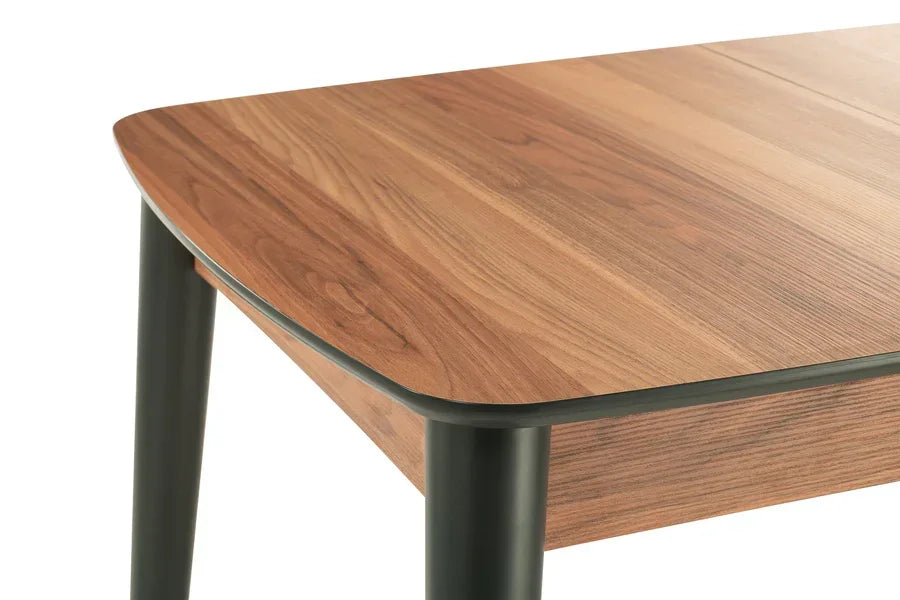Close-up of wooden dining table corner with black metal legs