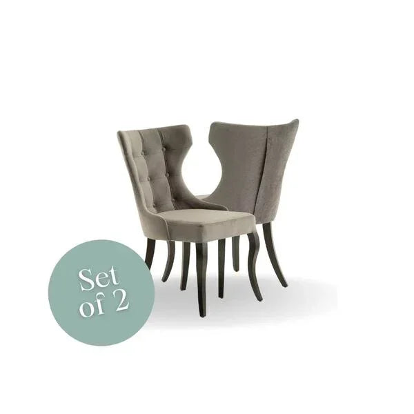 Pair of grey upholstered dining chairs with buttoned backs and dark curved legs