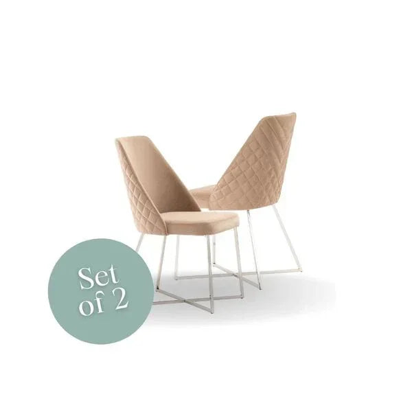 Set of two beige dining chairs with quilted backs and white metal legs