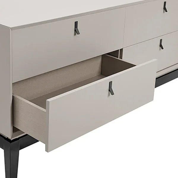 Modern beige chest of drawers with black handles and one open drawer