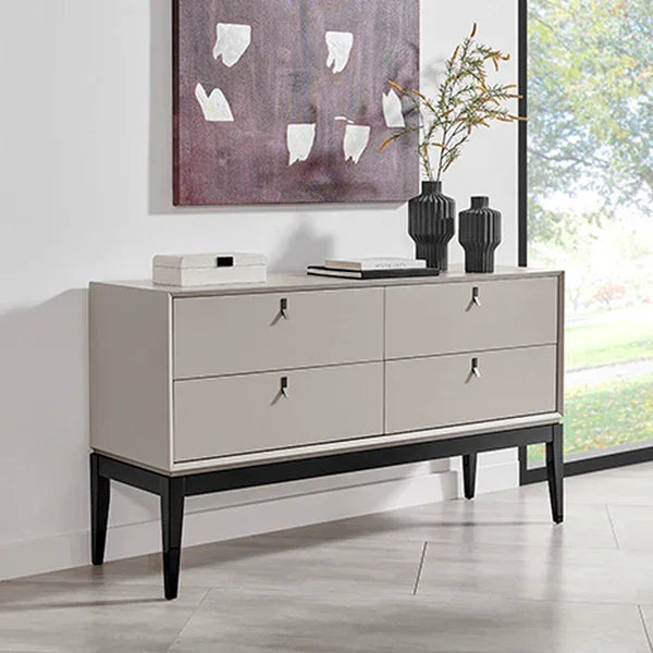 Modern grey sideboard with black legs and four drawers by window, decorated with vases