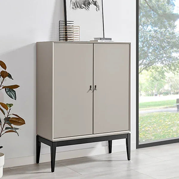 Modern grey storage cabinet with black legs in bright living room, books and artwork on top