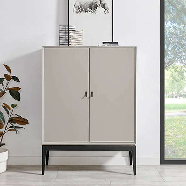 Beige storage cabinet with black metal legs in modern living room, potted plant nearby