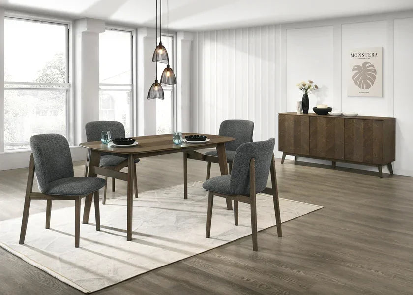 Dark wood dining table set with four grey chairs on a rug in a bright modern dining room