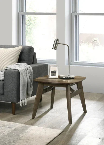 Mid-century modern wooden side table beside grey sofa, styled with lamp and photo frame