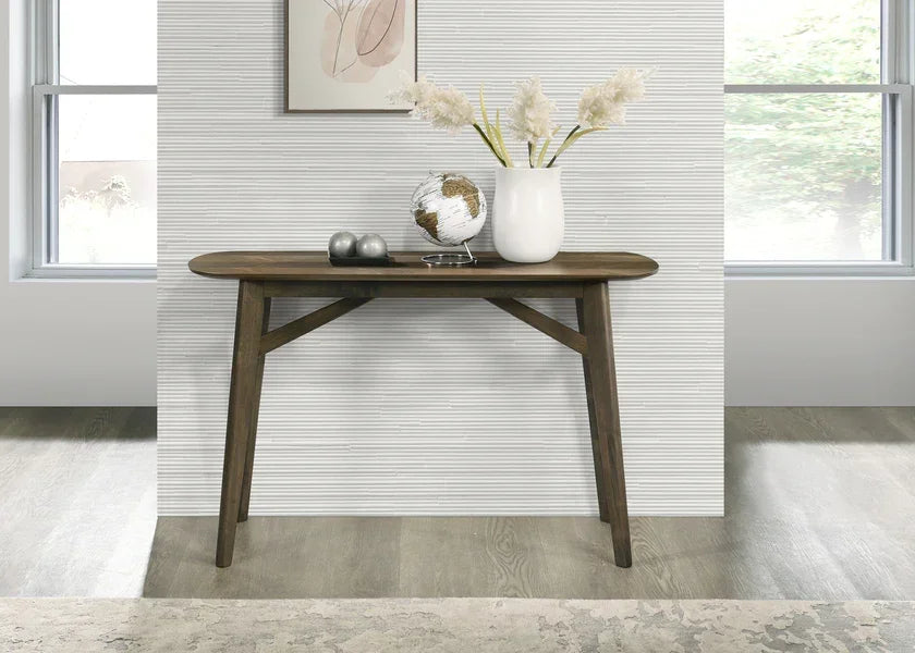 Dark wood console table in modern hallway with vase, globe and decorative objects