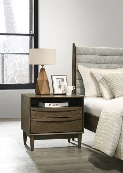 Wooden bedside table with two drawers beside upholstered bed in modern bedroom