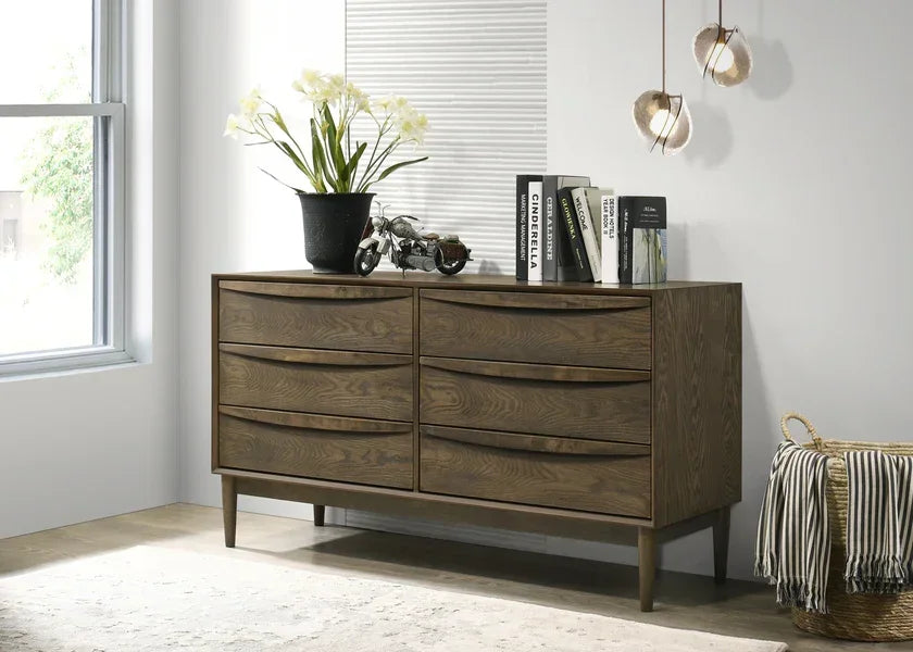 Dark wood chest of drawers with six handles, decorative vase and books, modern interior
