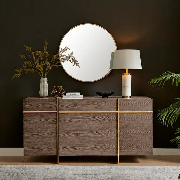 Modern sideboard with wood finish and gold accents, table lamp and decor, round wall mirror