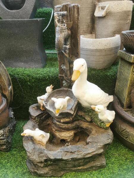 Garden duck water feature with white duck and ducklings on artificial grass display